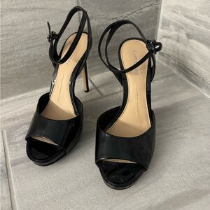 Size 10 high heel shiny black dress shoe with ankle strap.